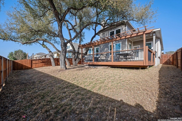 rear view of house with a deck, a yard, and a fenced backyard