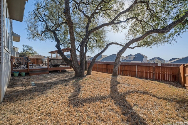 view of yard with a wooden deck and a fenced backyard