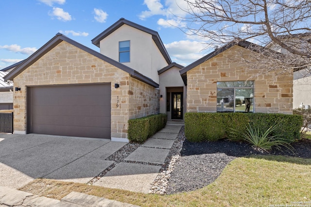 view of front of house with stucco siding, stone siding, concrete driveway, and an attached garage