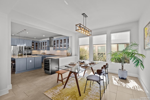 dining space with beverage cooler, recessed lighting, and baseboards