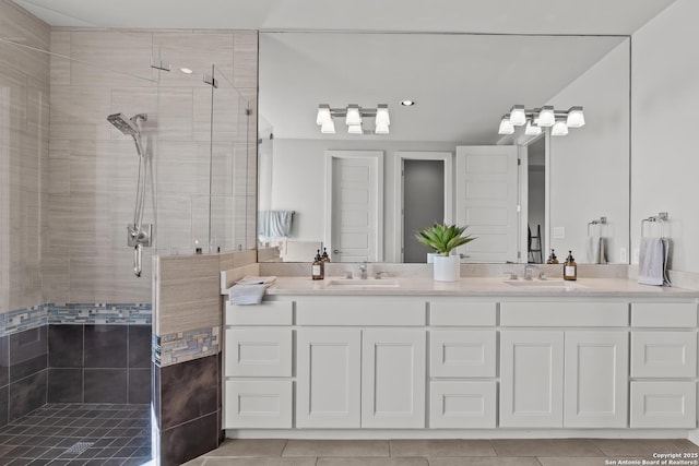 bathroom featuring double vanity, a stall shower, and a sink