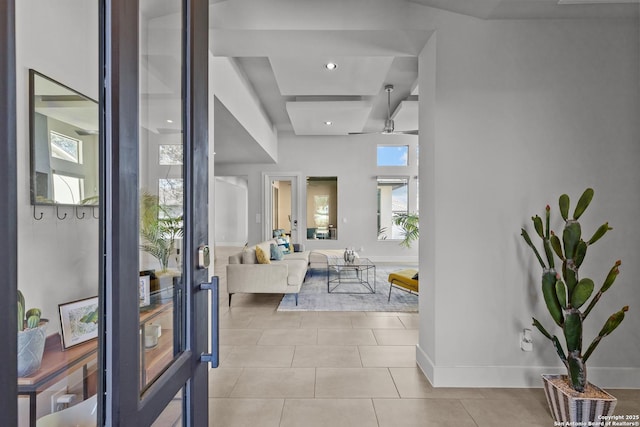 tiled foyer entrance with baseboards and ceiling fan