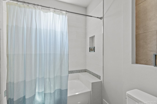 bathroom featuring shower / tub combo with curtain and toilet