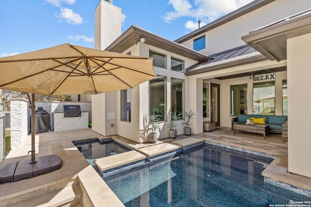 back of house featuring a standing seam roof, an in ground hot tub, a patio, and an outdoor hangout area