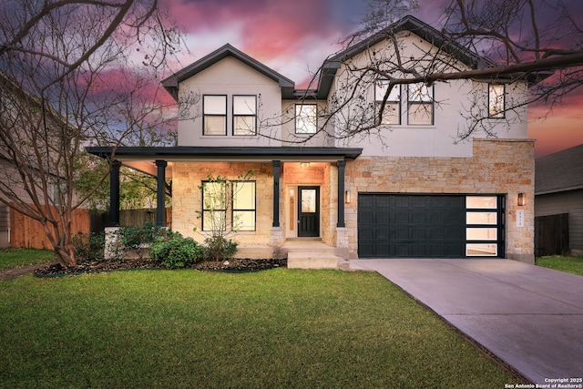 view of front of house with stucco siding, stone siding, a yard, and driveway