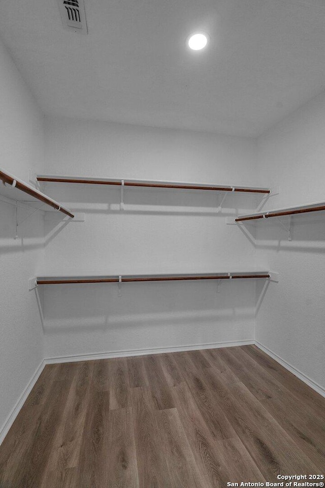 walk in closet with visible vents and wood finished floors