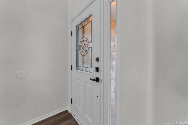 interior space featuring baseboards and dark wood-style flooring