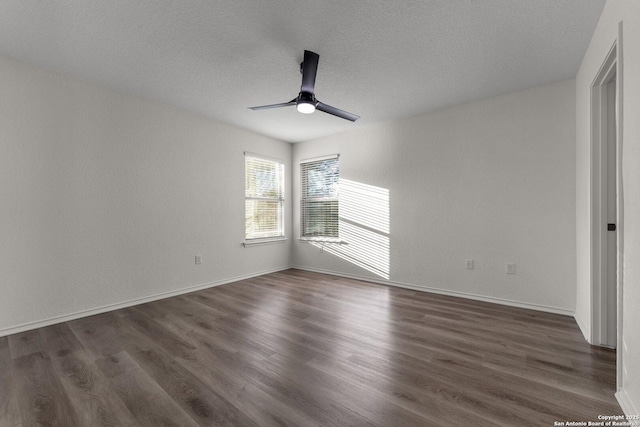 empty room featuring baseboards, dark wood-type flooring, and a ceiling fan