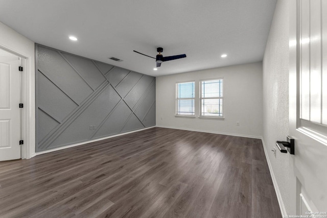 empty room with a ceiling fan, visible vents, baseboards, dark wood finished floors, and recessed lighting