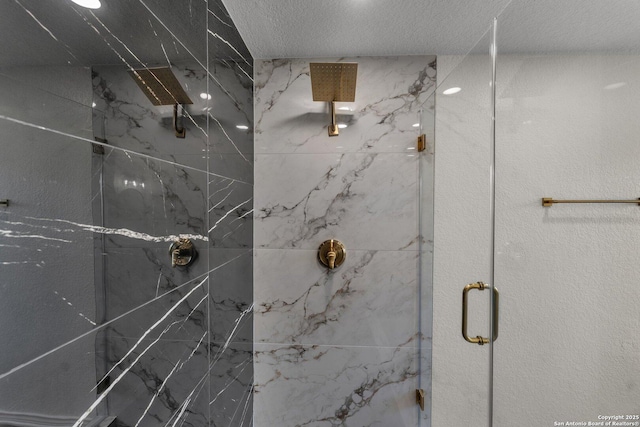 bathroom with a marble finish shower and a textured ceiling