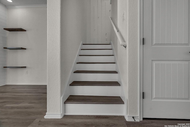 stairway with wood finished floors and baseboards