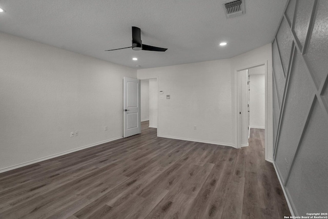 unfurnished bedroom featuring visible vents, dark wood-type flooring, a textured ceiling, baseboards, and ceiling fan