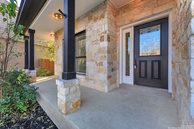 entrance to property featuring stone siding and covered porch