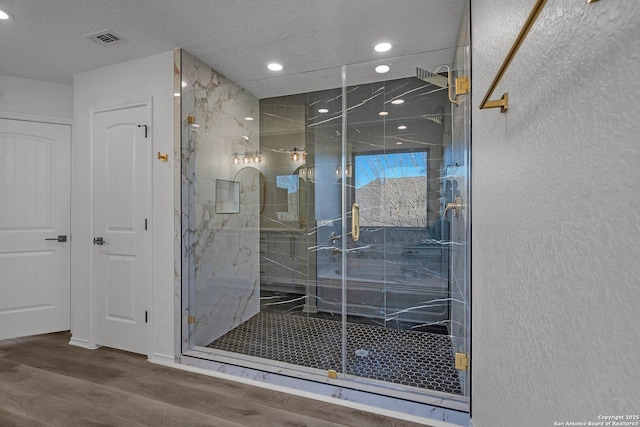 full bathroom featuring a marble finish shower, visible vents, and wood finished floors