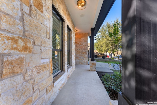 property entrance featuring covered porch and stone siding