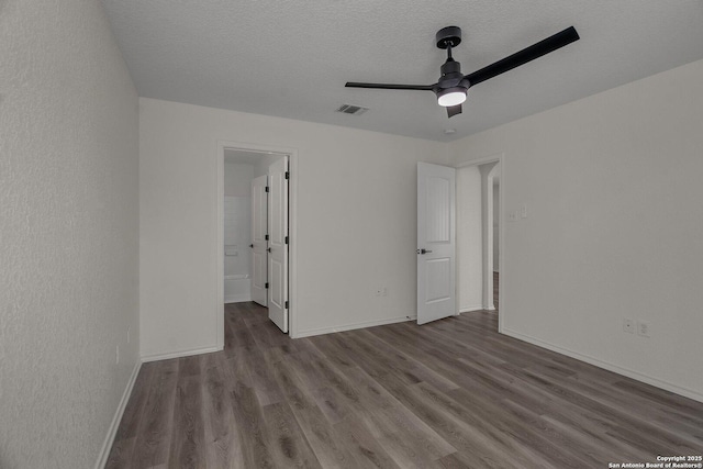 unfurnished bedroom featuring wood finished floors, visible vents, baseboards, ceiling fan, and a textured ceiling