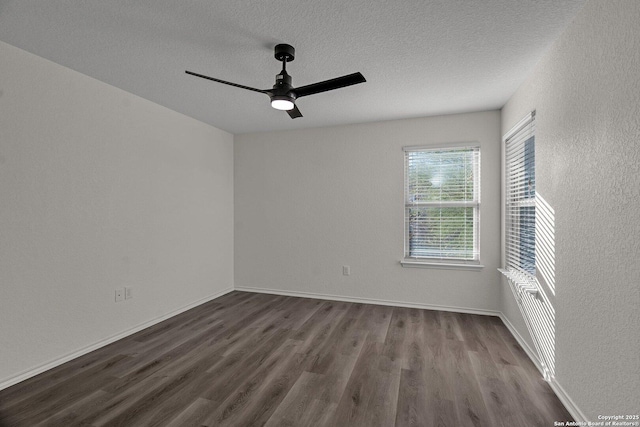 spare room with baseboards, a textured ceiling, dark wood finished floors, and a ceiling fan