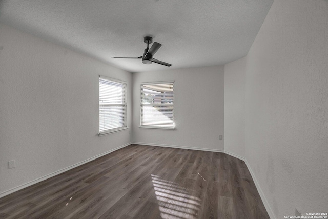 empty room with ceiling fan, baseboards, wood finished floors, a textured wall, and a textured ceiling