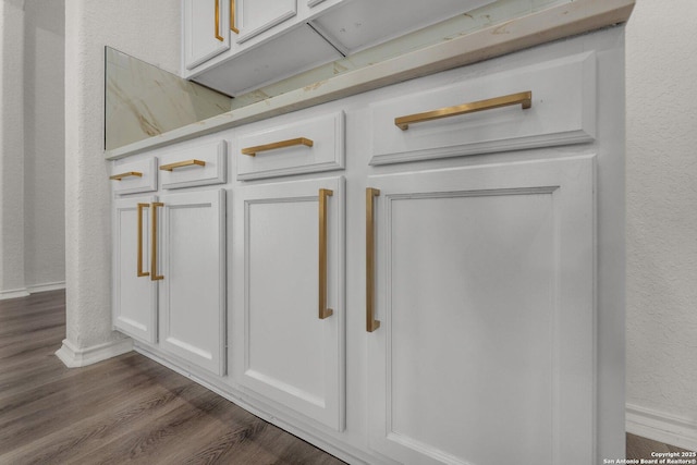 interior details with wood finished floors, baseboards, and a textured wall