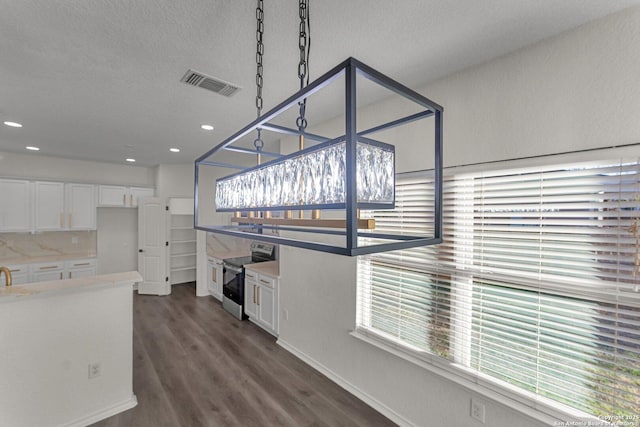 kitchen with electric range, visible vents, dark wood-type flooring, white cabinetry, and light countertops