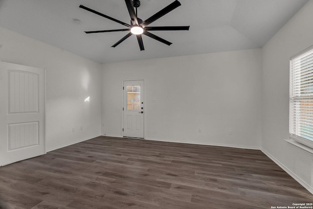 empty room featuring dark wood finished floors, baseboards, and ceiling fan