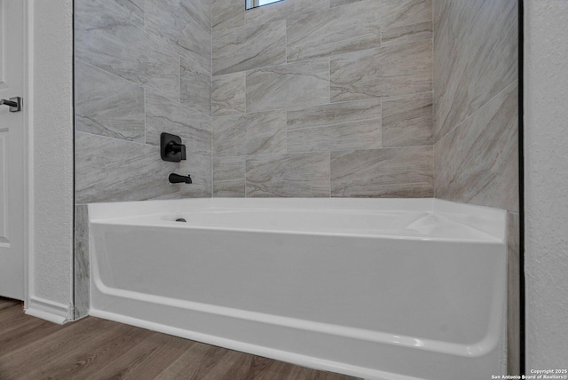 full bath featuring a bathtub, walk in shower, and wood finished floors