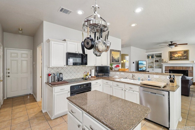 kitchen featuring visible vents, black appliances, a sink, open floor plan, and a peninsula