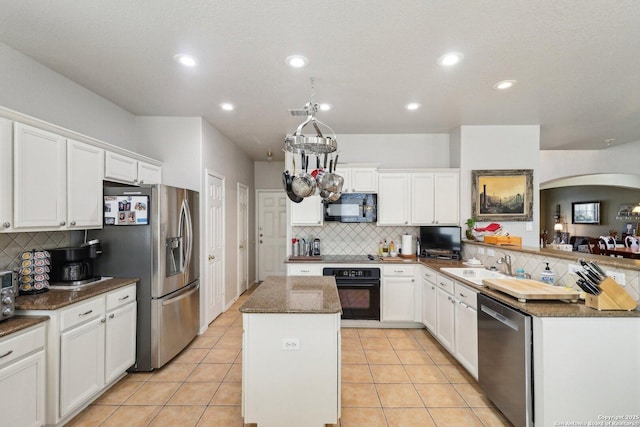 kitchen with black appliances, a kitchen island, light tile patterned flooring, white cabinetry, and a sink