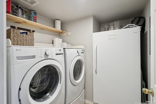 clothes washing area with washing machine and clothes dryer, laundry area, and visible vents