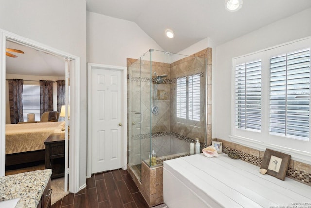 ensuite bathroom featuring wood finish floors, connected bathroom, lofted ceiling, and a shower stall