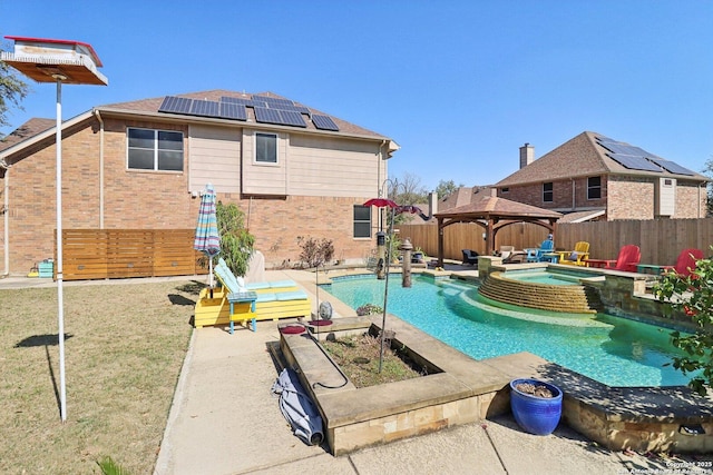 view of swimming pool featuring a pool with connected hot tub, a gazebo, a lawn, a fenced backyard, and a patio