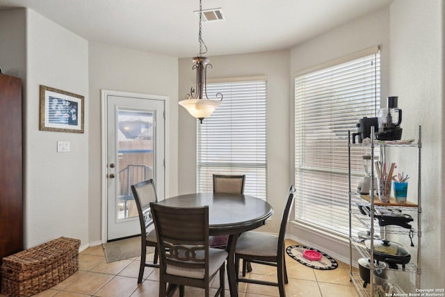 dining space with light tile patterned floors, visible vents, and baseboards