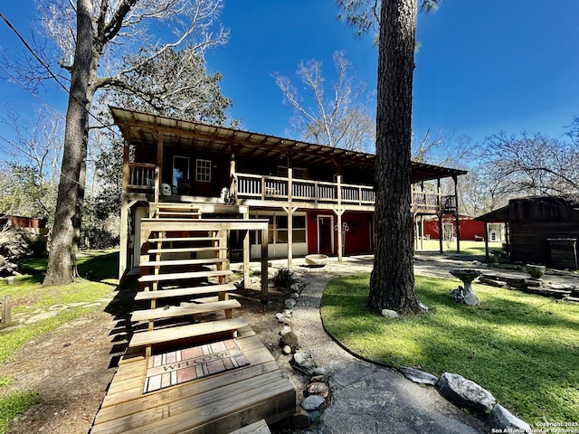 back of property with stairway, a yard, and a deck