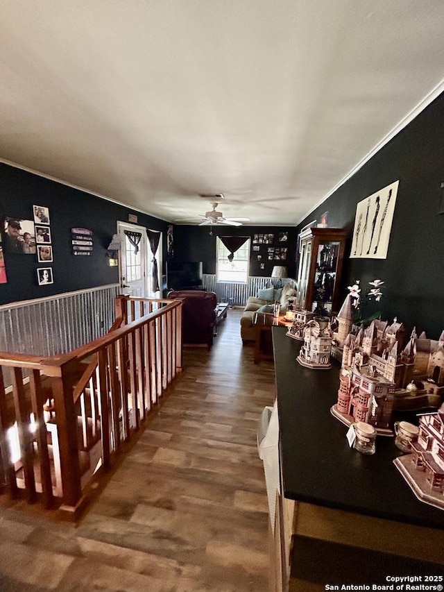 interior space with ceiling fan, wood finished floors, and crown molding