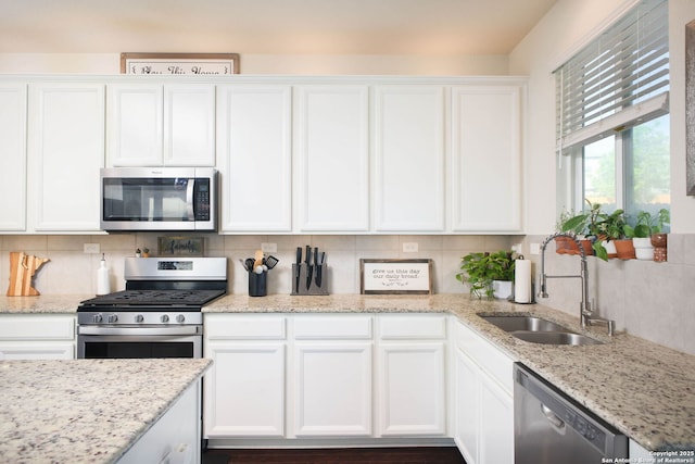 7611 Ponderosa Pne, Boerne, TX 78015 - kitchen featuring light stone counters, a sink, tasteful backsplash, appliances with stainless steel finishes, and white cabinetry
