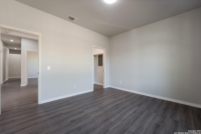 empty room featuring dark wood finished floors, baseboards, and visible vents