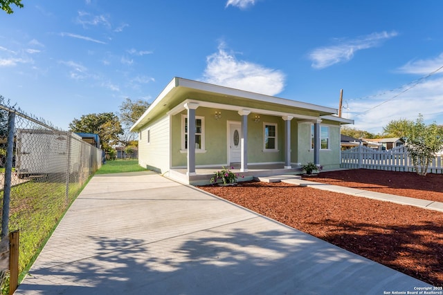 view of front of property featuring stucco siding, covered porch, and fence