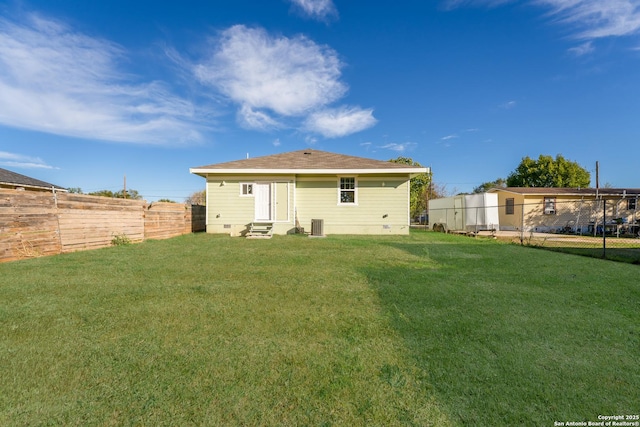 rear view of house with crawl space, a yard, a fenced backyard, and entry steps