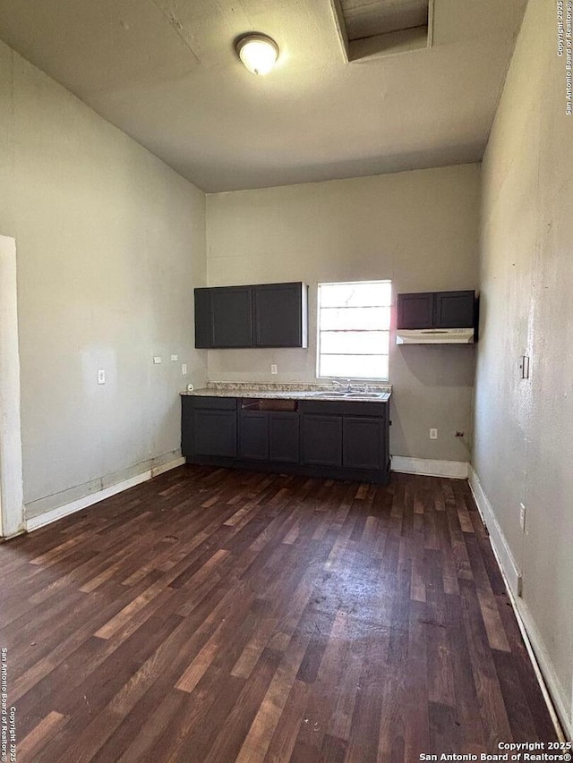 kitchen with dark wood finished floors, light countertops, and baseboards