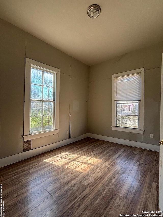 unfurnished room featuring baseboards and wood finished floors