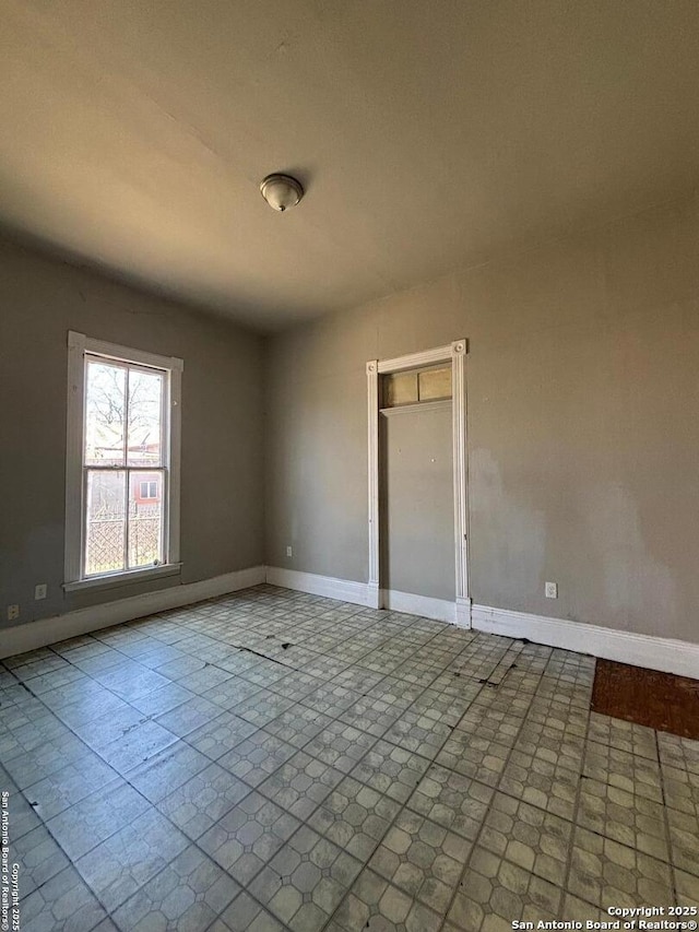 unfurnished room featuring baseboards