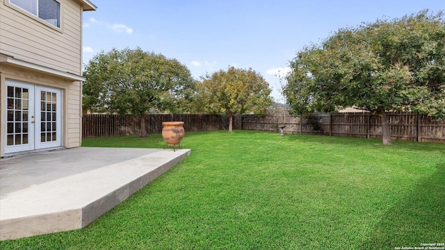 view of yard featuring a patio area, french doors, and a fenced backyard