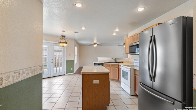 kitchen featuring a kitchen island, french doors, appliances with stainless steel finishes, light tile patterned flooring, and light countertops