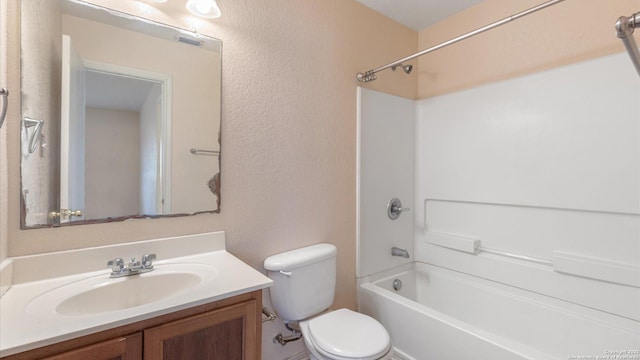 bathroom featuring vanity, visible vents, shower / tub combination, toilet, and a textured wall