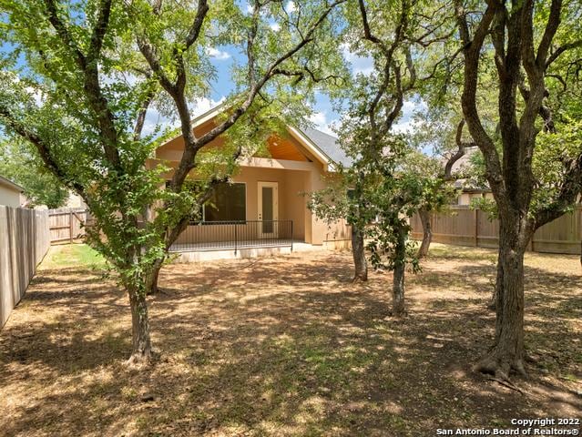 back of house with stucco siding and a fenced backyard