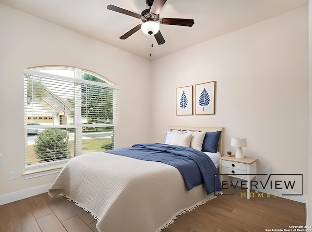 bedroom featuring ceiling fan, baseboards, and wood finished floors