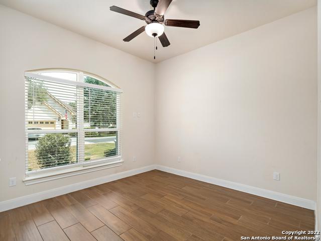 unfurnished room with a wealth of natural light, baseboards, and wood finished floors
