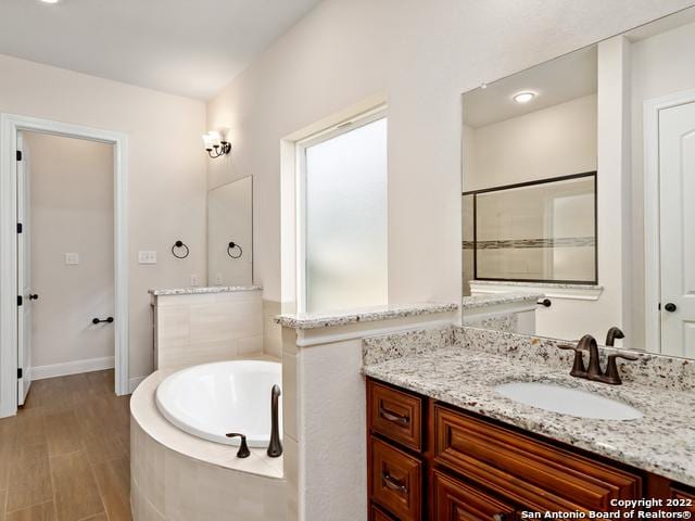 full bathroom with vanity and a bath