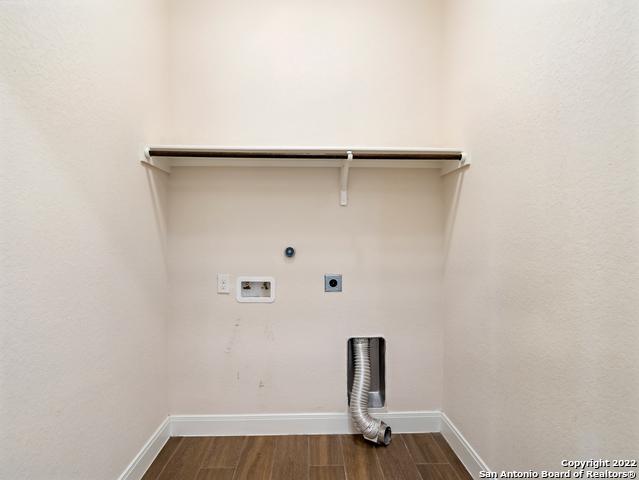 laundry room with hookup for a washing machine, baseboards, dark wood finished floors, laundry area, and electric dryer hookup