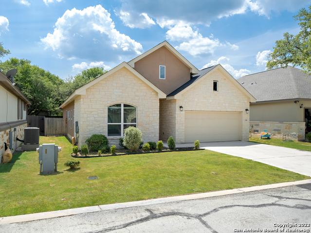 view of front facade with fence, concrete driveway, a front yard, an attached garage, and central AC unit